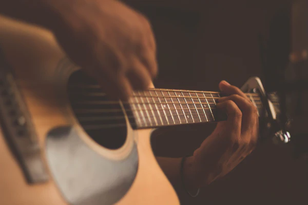 Akustik gitar çalan ellerin yakın plan görüntüsü